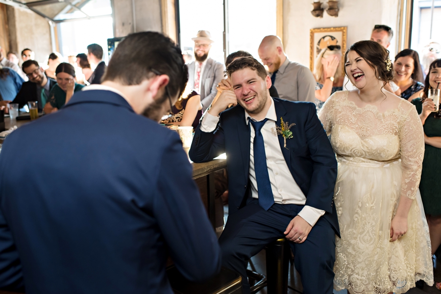 The wedding couple laughing at the best man's speech.